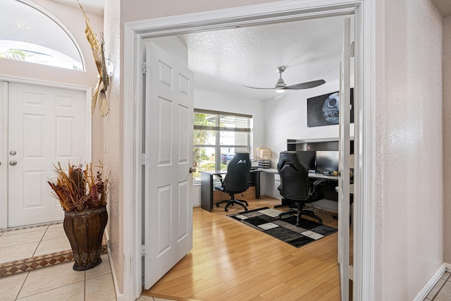 office area featuring a textured ceiling, light wood-style floors, and ceiling fan