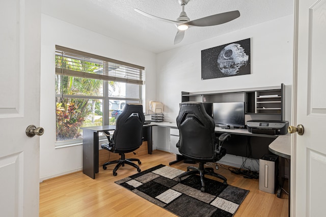 home office with ceiling fan, baseboards, a textured ceiling, and wood finished floors