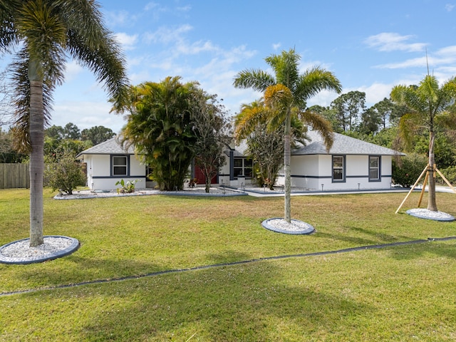 view of front of property with a front yard, fence, and stucco siding