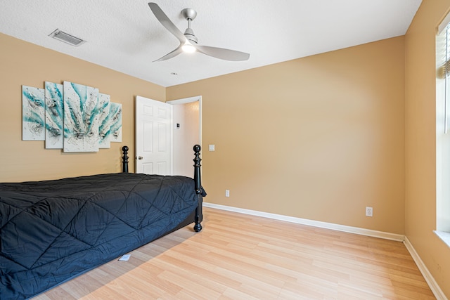bedroom with visible vents, baseboards, light wood-style floors, and ceiling fan