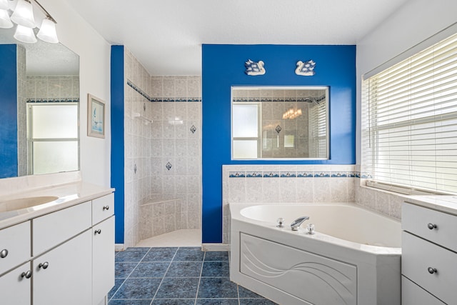 bathroom with a bath, a walk in shower, vanity, and a textured ceiling