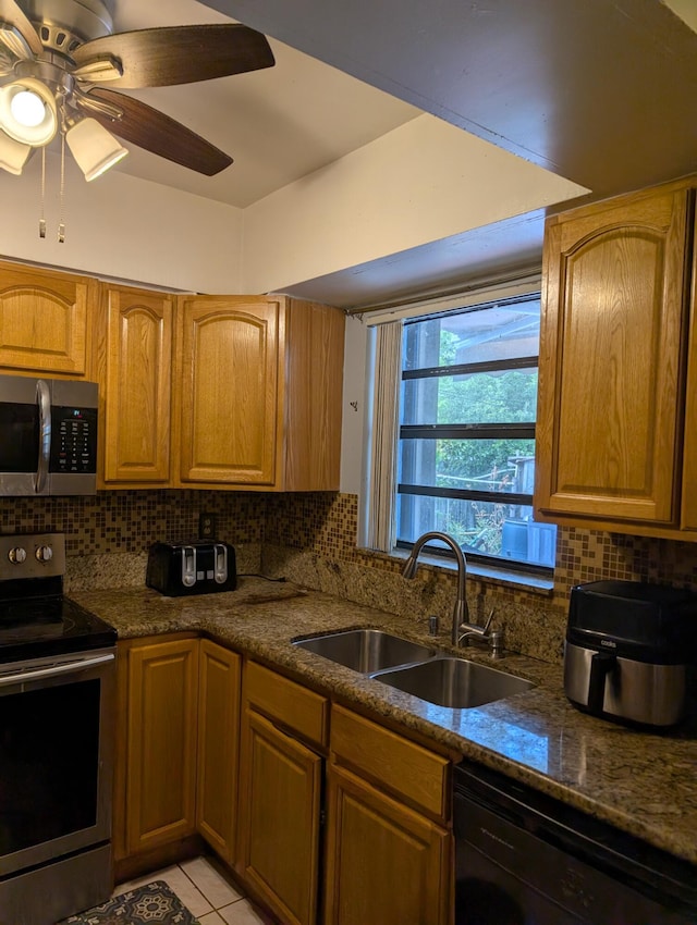 kitchen featuring a sink, stainless steel appliances, ceiling fan, and decorative backsplash