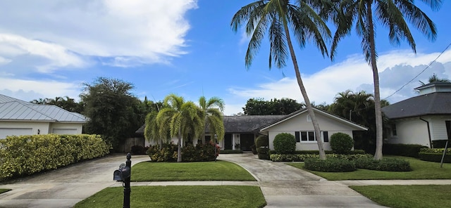 view of front facade with concrete driveway and a front lawn