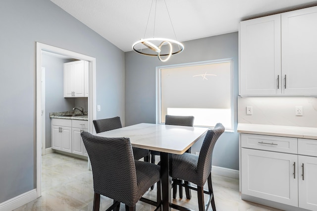 13853 Via Da Vinci, Delray Beach, FL 33446 - dining space with light marble finish floors, vaulted ceiling, a chandelier, and baseboards
