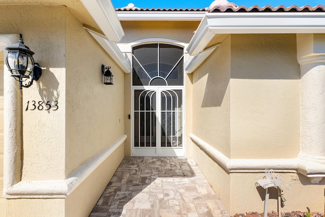 13853 Via Da Vinci, Delray Beach, FL 33446 - view of exterior entry with stucco siding and a tiled roof