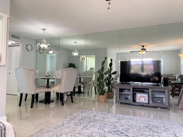 dining space with a textured ceiling, visible vents, and ceiling fan