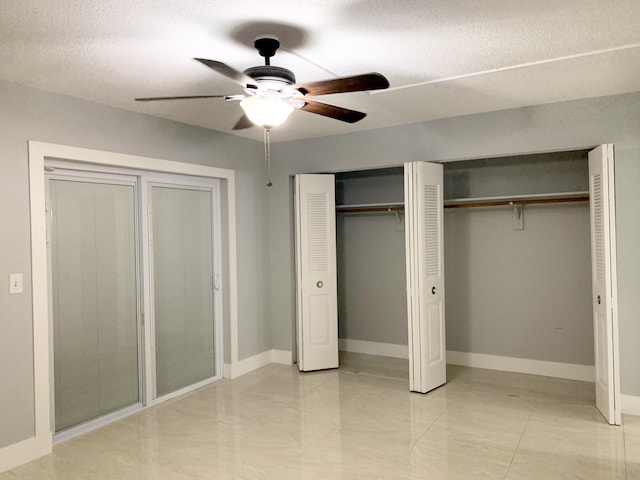 unfurnished bedroom featuring a textured ceiling, baseboards, multiple closets, and a ceiling fan