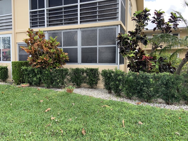 view of side of property with a yard and stucco siding