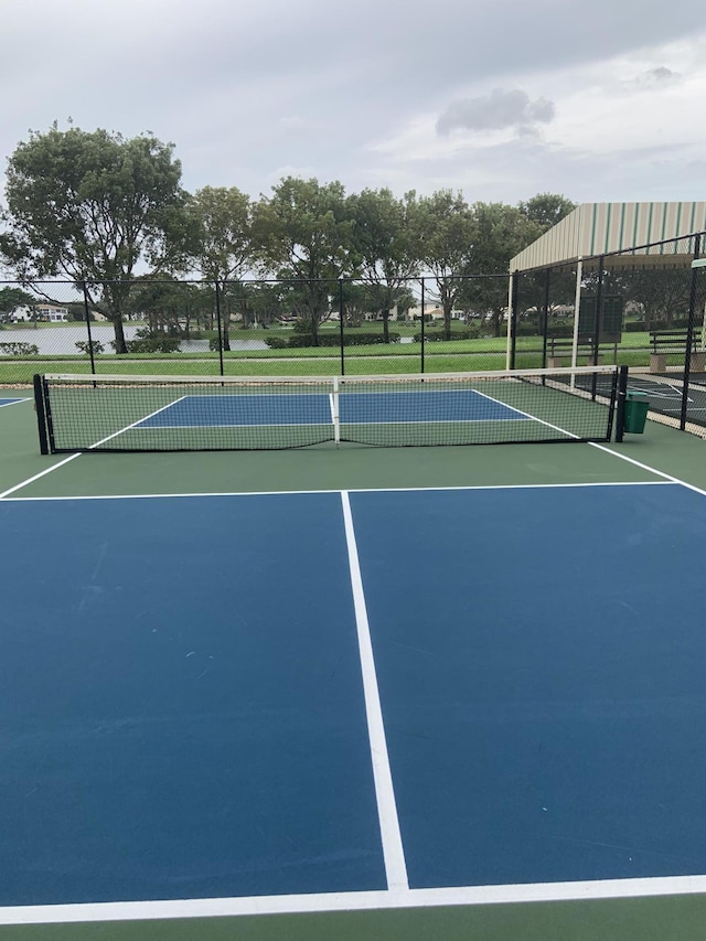 view of tennis court featuring fence