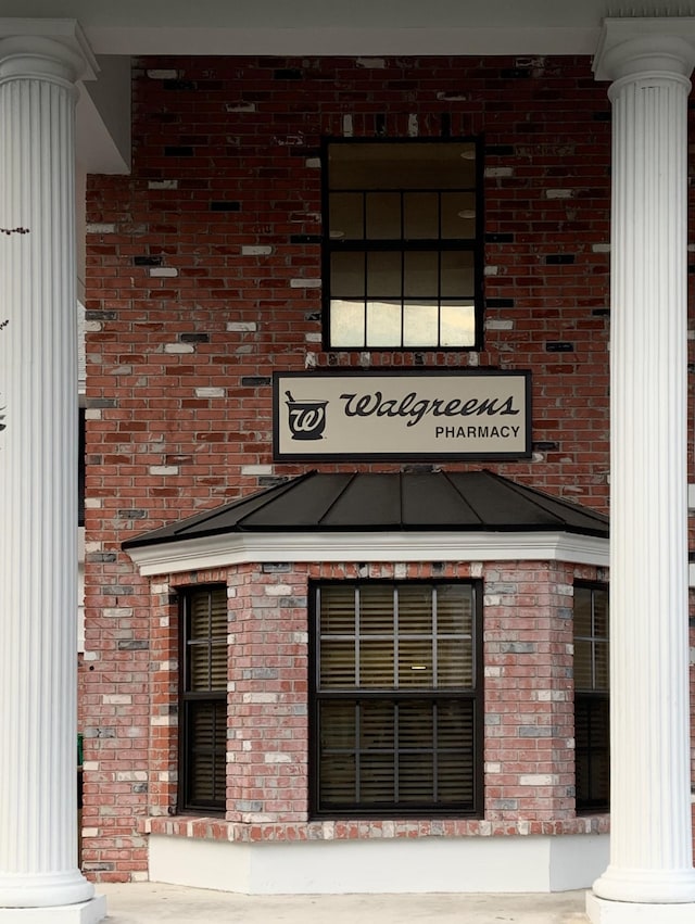 entrance to property featuring brick siding