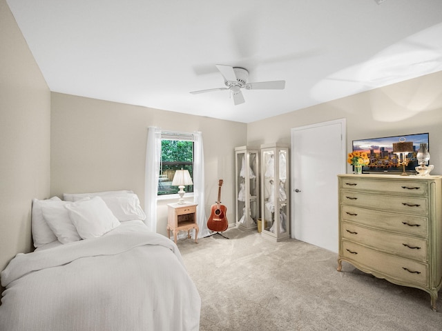 bedroom featuring light colored carpet and a ceiling fan