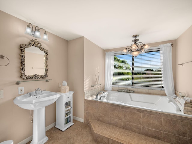 full bathroom with baseboards, a garden tub, an inviting chandelier, and tile patterned flooring