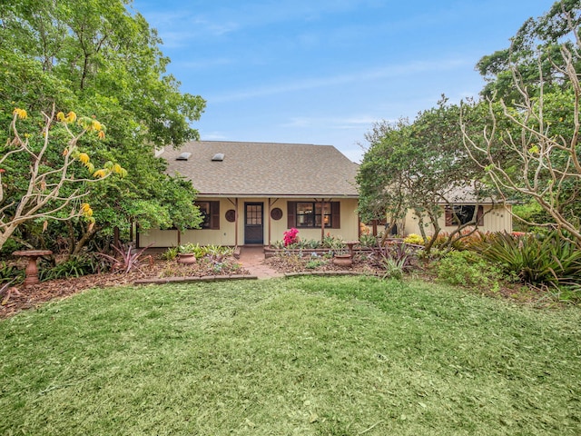 ranch-style home featuring a front lawn and a shingled roof