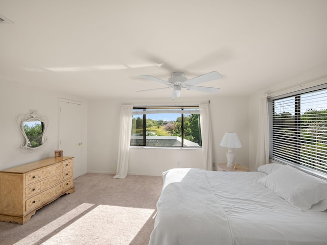 bedroom featuring baseboards, light carpet, and ceiling fan