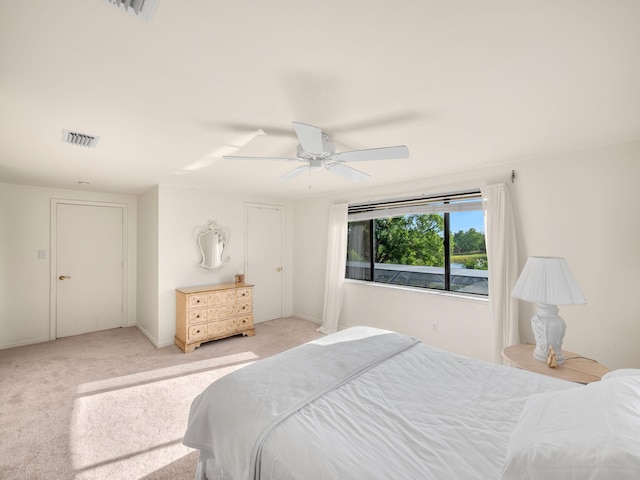 bedroom featuring visible vents, baseboards, light colored carpet, and ceiling fan