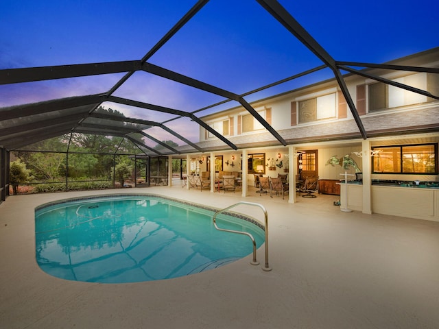 pool with glass enclosure and a patio area