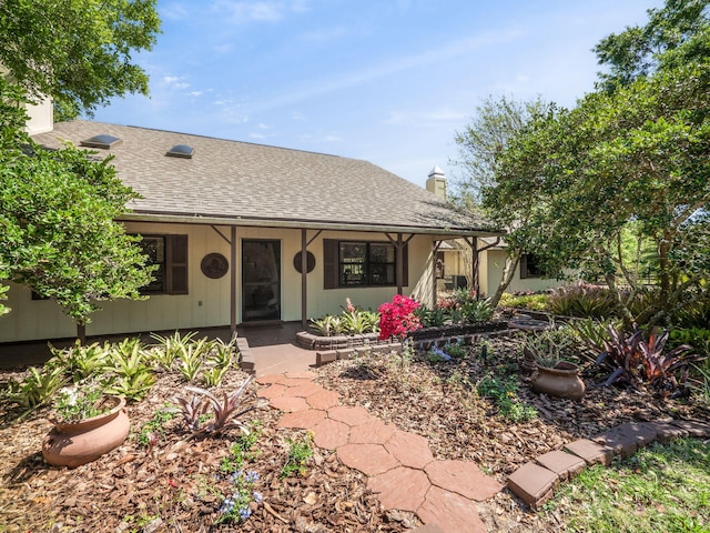 view of front of house featuring roof with shingles and a chimney