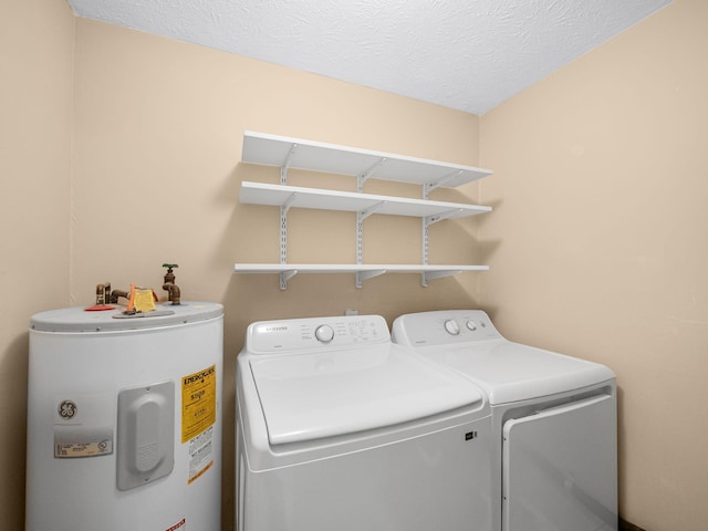 clothes washing area featuring laundry area, washing machine and dryer, a textured ceiling, and electric water heater