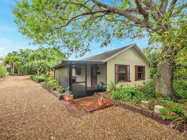 view of front facade with roof with shingles and a lanai