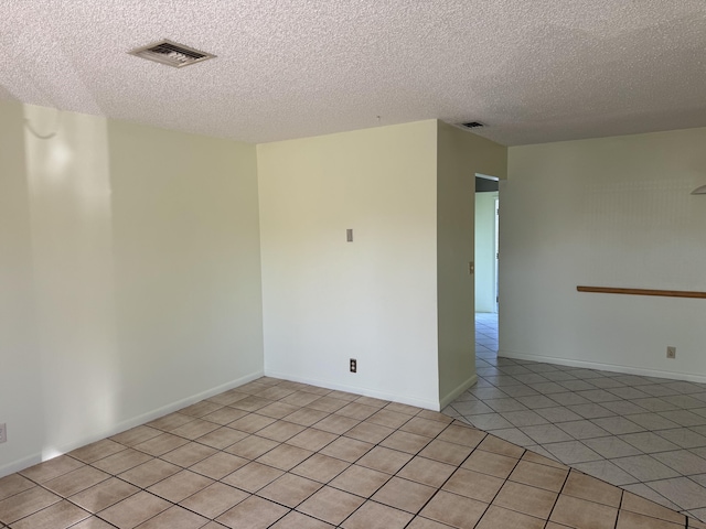 unfurnished room with visible vents, baseboards, a textured ceiling, and light tile patterned flooring