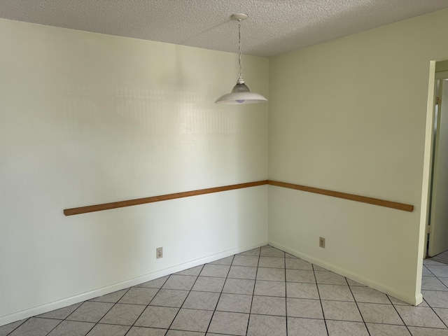 unfurnished dining area with light tile patterned floors and a textured ceiling