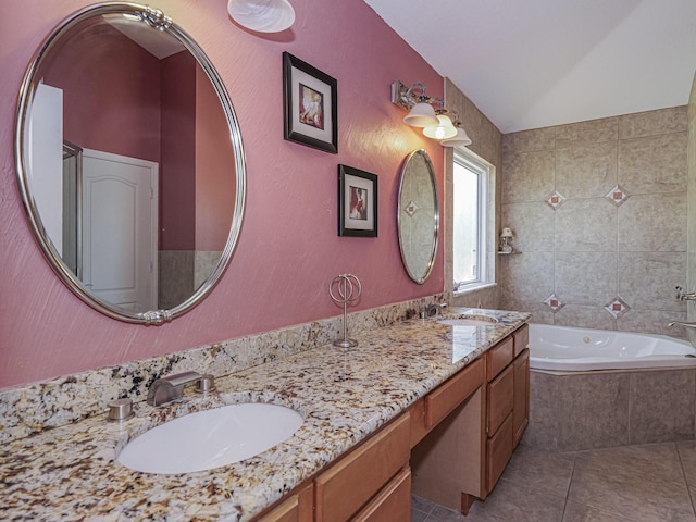 full bathroom with double vanity, tiled bath, tile patterned floors, and a sink