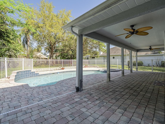 view of swimming pool with a pool with connected hot tub, a patio, a ceiling fan, and a fenced backyard