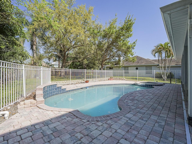 view of swimming pool with a patio, a pool with connected hot tub, and a fenced backyard