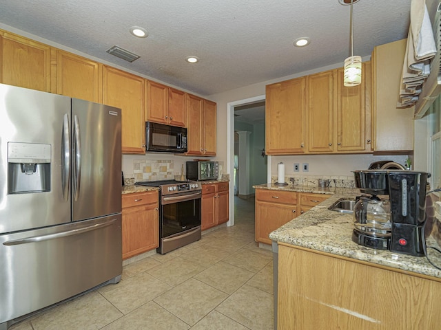 kitchen featuring light stone counters, light tile patterned floors, visible vents, stainless steel appliances, and pendant lighting