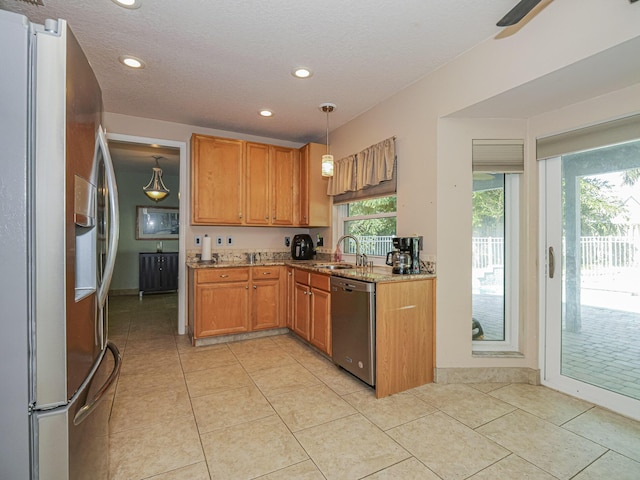 kitchen featuring light tile patterned floors, stainless steel appliances, light stone countertops, and brown cabinets