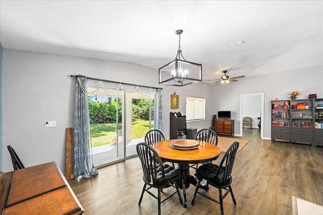 dining space featuring visible vents, wood finished floors, and ceiling fan with notable chandelier