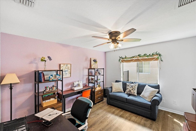 office with visible vents, wood finished floors, and a ceiling fan