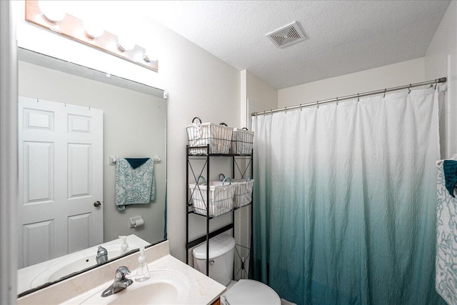 full bath with visible vents, toilet, vanity, a shower with shower curtain, and a textured ceiling