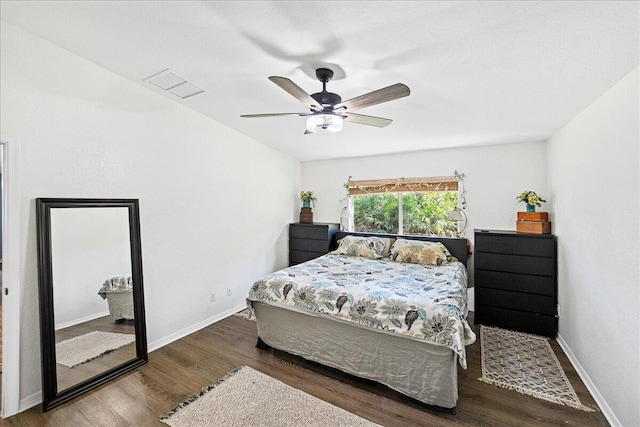 bedroom with visible vents, a ceiling fan, baseboards, and wood finished floors