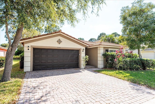 view of front facade with stucco siding, decorative driveway, a garage, and a tile roof