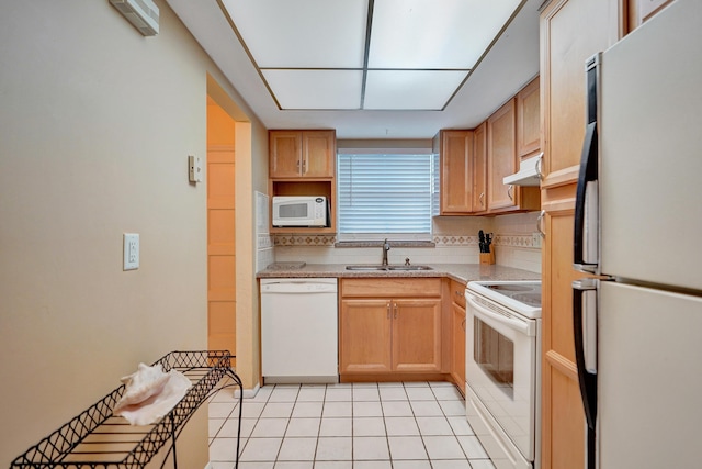 kitchen with white appliances, a sink, light countertops, under cabinet range hood, and backsplash