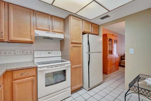 kitchen featuring white appliances, light tile patterned floors, visible vents, under cabinet range hood, and backsplash