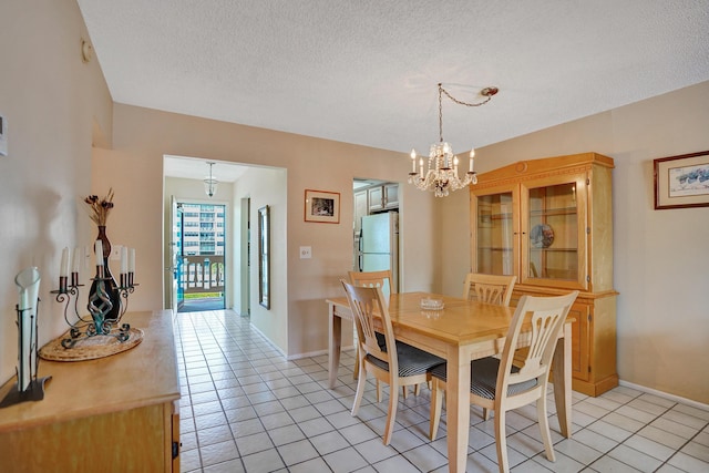 dining area with baseboards, a textured ceiling, a chandelier, and light tile patterned flooring