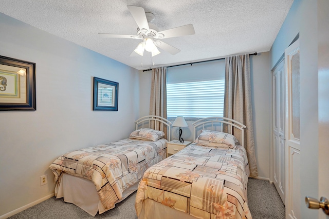 carpeted bedroom featuring baseboards, a textured ceiling, and ceiling fan