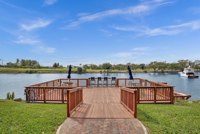 dock area with a yard and a water view