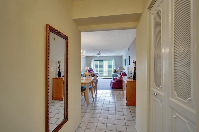 hallway featuring light tile patterned floors and a textured ceiling