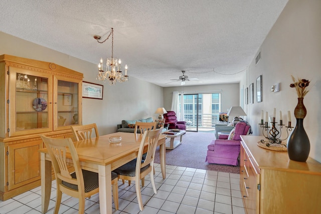 dining space with visible vents, light colored carpet, ceiling fan with notable chandelier, light tile patterned flooring, and a textured ceiling