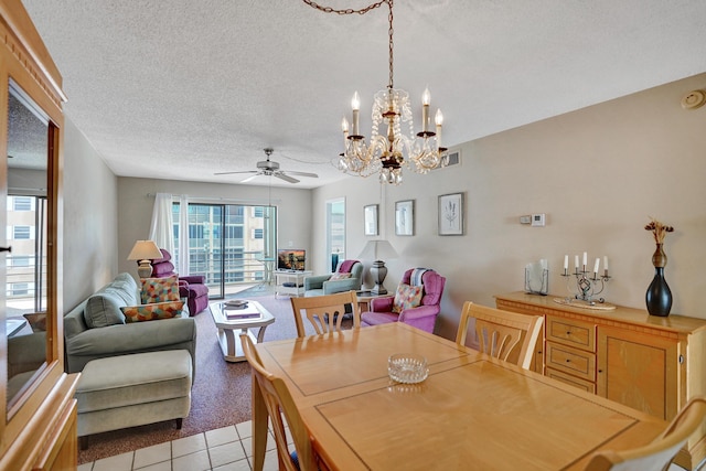 dining space featuring light tile patterned floors, ceiling fan with notable chandelier, visible vents, and a textured ceiling