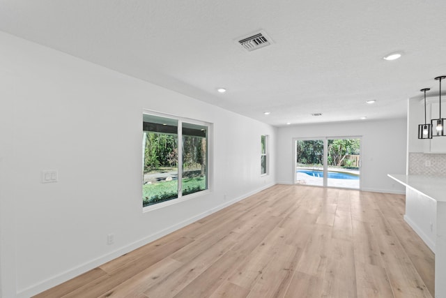 empty room featuring visible vents, recessed lighting, baseboards, and light wood-style floors