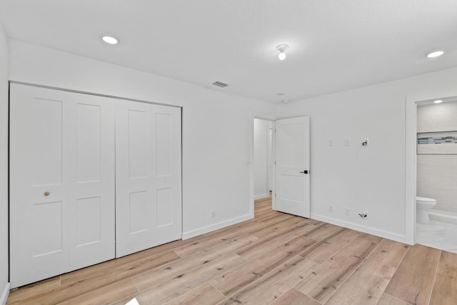 unfurnished bedroom with light wood-style floors, a closet, connected bathroom, recessed lighting, and baseboards