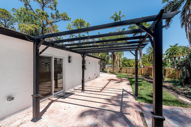 view of patio with a pergola and fence