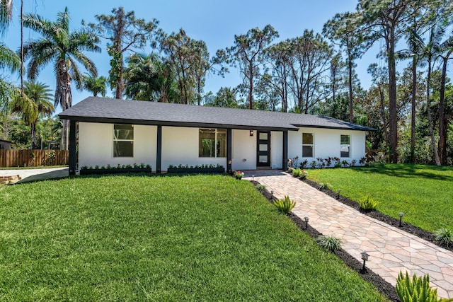 single story home featuring a front yard, fence, and stucco siding