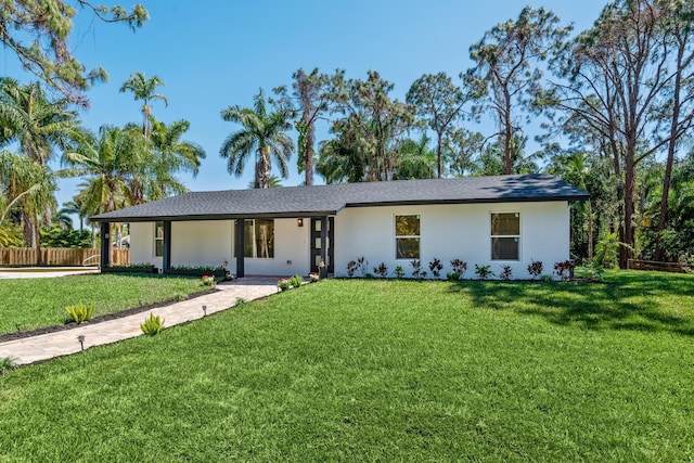 view of front of home featuring stucco siding, a front yard, and fence