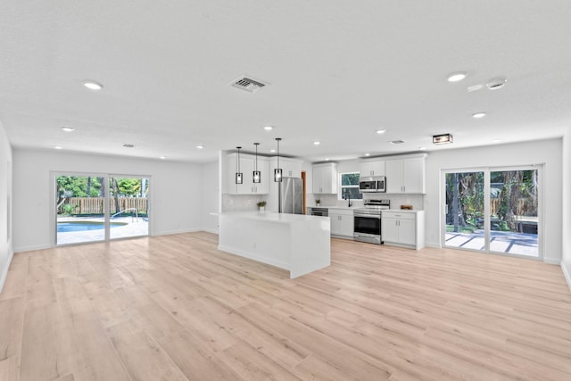 kitchen featuring visible vents, tasteful backsplash, open floor plan, appliances with stainless steel finishes, and light countertops