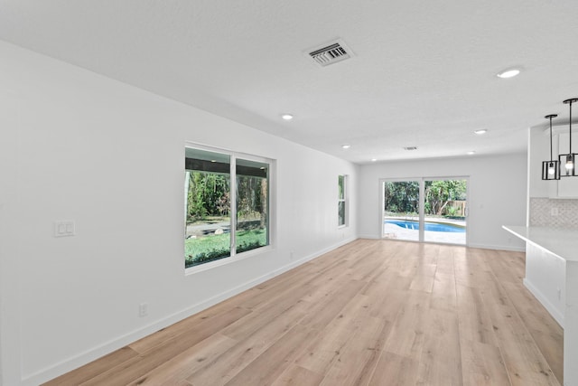 unfurnished living room with light wood-style flooring, recessed lighting, and baseboards